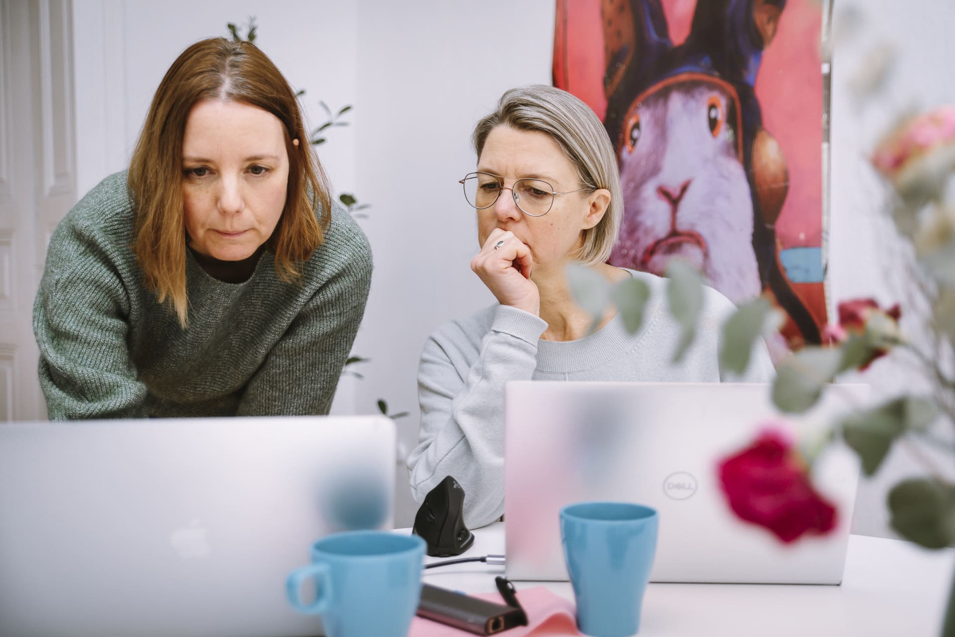 Zwei Unternehmerinnen arbeiten konzentriert am Laptop bei einer Coworking-Session