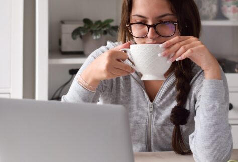 Frau am Laptop mit einer Kaffeetasse