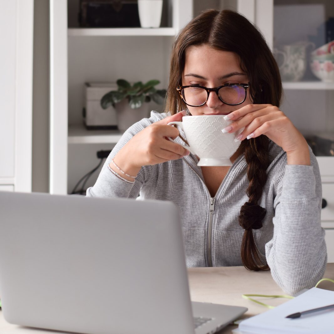 Frau am Laptop mit einer Kaffeetasse